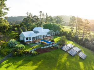 eine Luftansicht eines Hauses mit Sonnenkollektoren auf dem Rasen in der Unterkunft Paroa Bay Winery in Russell