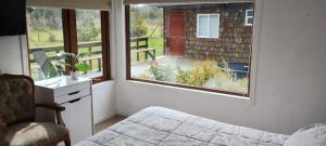 a bedroom with a bed and a window with a balcony at Hermosa casa parcela puerto varas in Puerto Varas +4 photos