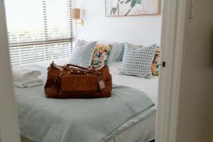 a bag sitting on a bed in a room at Family Fun On The Farm! Close to Kenilworth Stylish Feed Friendly Cows Breathtaking 360 Views in Obi Obi +33 photos