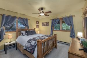 a bedroom with a bed and a ceiling fan at Bear Paw by NW Comfy Cabins in Leavenworth