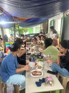 un gruppo di persone sedute a un tavolo che mangiano cibo di Home Sun Moon - Home 1 a Phan Thiet