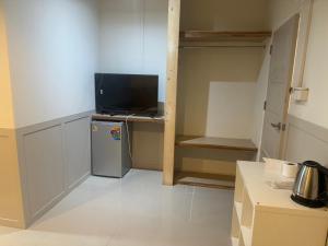 a kitchen with a small refrigerator and a television at The Elegant Bangna Suvarnabhumi in Ban Map Prasoe