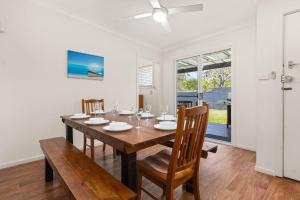 Un comedor con mesa y sillas de madera. en Huskisson Delight! by Experience Jervis Bay, en Huskisson 16 fotos más
