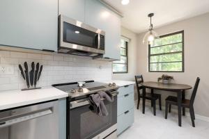 eine Küche mit Herd oberer Ofen neben einem Tisch in der Unterkunft Be A Nomad - Newly renovated 1br apartment in Jacksonville