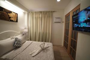 a hotel room with a bed with a tv on the wall at 1775 Adriatico Suites in Manila