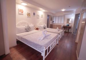 a bedroom with two beds with white sheets at 1775 Adriatico Suites in Manila