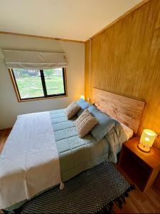 a bedroom with a large bed with a window at Siempre Verde in Puerto Tranquilo