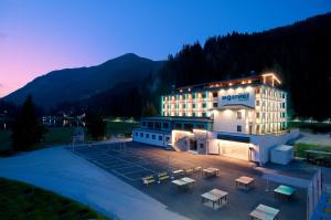 budynek hotelowy z parkingiem przed nim w obiekcie Hotel Sportwelt w mieście Zauchensee