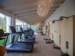 eine Reihe von Heimtrainern in einem Fitnessraum mit großem Fenster in der Unterkunft Villa Favorita - Parkhotel Delta in Ascona