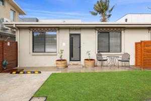トーキーにあるSuperb Esplanade Beach House 8のテーブルと椅子のあるパティオのある家