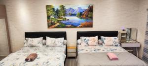 a bedroom with two beds and a painting on the wall at Spacious 2 King Bed Family Room 56 Sqm PODOMORO APARTMENT Tower Liberty 21st Floor with Mall Direct Access in Medan +32 photos