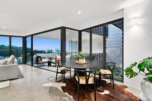 a dining room with a table and chairs on a balcony at Luxe Condo at Alex Beach in Alexandra Headland