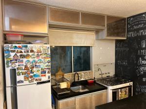 a kitchen with a refrigerator with magnets on it at Apartamento em Condomínio ao lado do Shopping in Ananindeua +8 photos