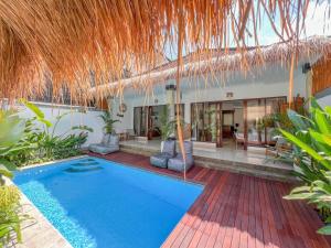 a swimming pool in front of a villa at Bubble Villa & Rice field view in Kerobokan