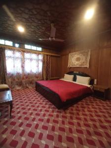 a bedroom with a large bed with a red blanket at SnowGoose Group of Houseboats in Srinagar
