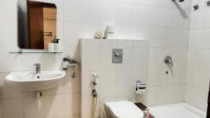 un bagno bianco con lavandino e WC di Qantab Village Stay a Qantab