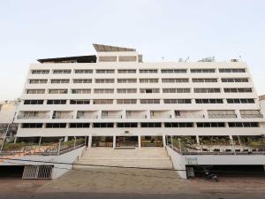 Un gran edificio blanco con una escalera al frente. en Palette Hotel Surya Vadodara, en Vadodara