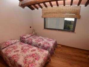 Dos camas en una habitación con ventana. en Tuscan Retreat in Aiale, en Lari