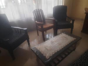 a living room with three chairs and a coffee table at Star villa dehiwala in Kalubowila West