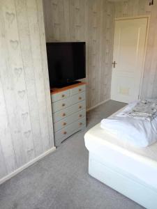 a bedroom with a television and a white dresser at 319mizen in Broadstone