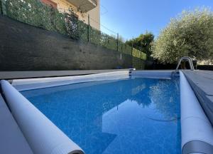 a swimming pool with blue water in front of a fence at ABC Holiday in Salò