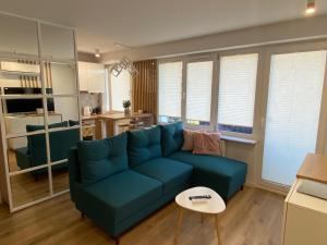 a living room with a blue couch and a table at DiM Suwałki Pułaskiego in Suwałki