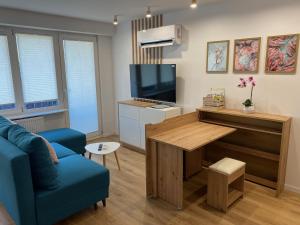 a living room with a blue couch and a television at DiM Suwałki Pułaskiego in Suwałki +7 photos