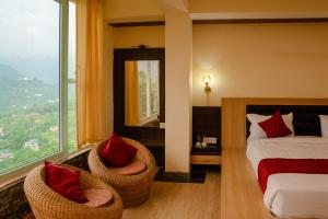 a bedroom with a bed and two chairs and a window at Casa Tranquila in Gangtok +73 photos