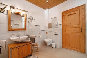 a bathroom with a sink and a toilet and a mirror at Ferienwohnung Böllenburg in Bernbeuren +34 photos