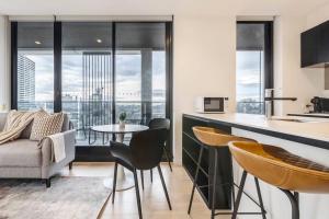 a kitchen and living room with a table and chairs at Sunlit & Sleek Condo in Lively St Kilda in Melbourne