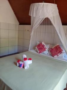 a bed with two dolls sitting on top of it at Tropicana Gili in Gili Meno