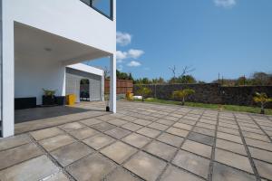 an open courtyard with a white building and a patio at Villa SERENITY neuve,4 chambres, 5 min de la plage in Calodyne