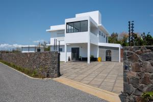 a white house with a stone wall at Villa SERENITY neuve,4 chambres, 5 min de la plage in Calodyne