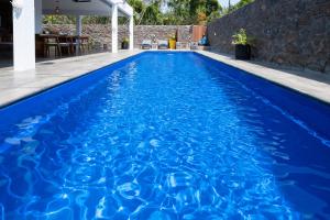 a blue swimming pool with blue water at Villa SERENITY neuve,4 chambres, 5 min de la plage in Calodyne +55 photos