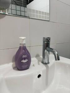 eine lila Flasche Seife auf einem Waschbecken im Badezimmer in der Unterkunft Mount Austin #Palazio A1 Muji-Style 2Pax in Johor Bahru