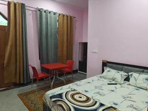 a bedroom with a bed and a table and chairs at Ram Ganga Valley Homestay in Sater