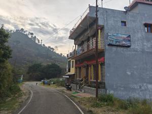a building sitting on the side of a road at Ram Ganga Valley Homestay in Sater