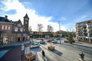 a city street with cars and a clock tower at Brasserie-Hotel Antje van de Statie in Weert