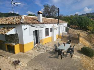 a white and yellow house with a table and chairs at La Jaima in Prado del Rey