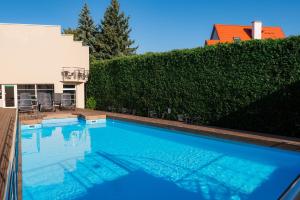 a swimming pool in front of a house at Vesiroos Apartment - Free parking in Pärnu