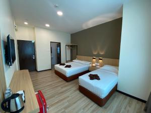 a hotel room with two beds and a television at Kaia Suite Semporna in Semporna