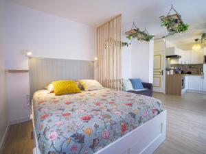 a bedroom with a large bed with a floral bedspread at Pause et Sérénité Studio de 28m2 in Cagnes-sur-Mer