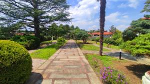 德鲁恩托Phi Hotel Homy Druento的树木和鲜花公园中的石头路径