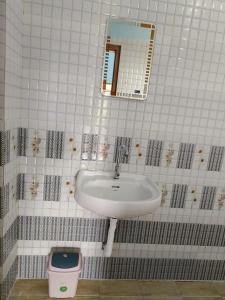 a bathroom with a sink and a mirror and a trash can at Travelmate Vagamon in Vagamon