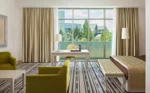 a hotel room with a desk and a couch and a window at Gashalti Health Hotel Naftalan in Naftalan
