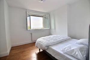 a white bedroom with a bed and a window at Maison de Vacances avec Vue sur mer - NAUSICAA in Boulogne-sur-Mer