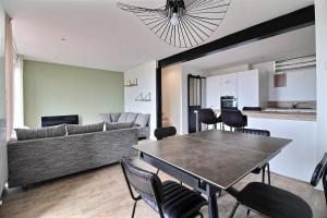 a living room with a couch and a table and chairs at Maison de Vacances avec Vue sur mer - NAUSICAA in Boulogne-sur-Mer