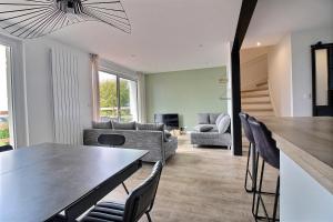 a dining room and living room with a table and chairs at Maison de Vacances avec Vue sur mer - NAUSICAA in Boulogne-sur-Mer