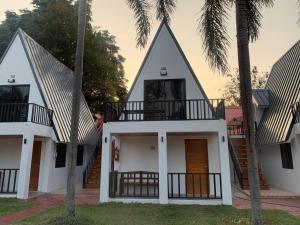 una casa con techos a tres aguas con palmeras en RainBow House Resort, en Kamphaeng Phet