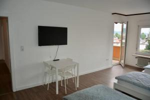 un soggiorno con un tavolo e una TV a parete di Großzügige Monteurwohnung mit TOP Anbindung a Bensheim